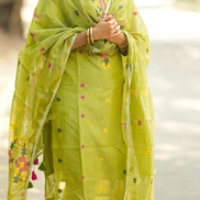 Woman wearing a green traditional outfit with floral patterns