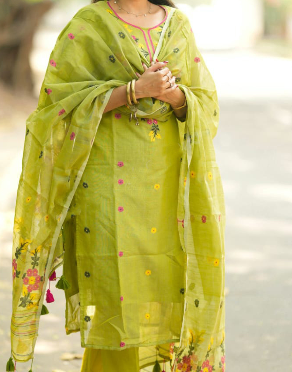 Woman wearing a green traditional outfit with floral patterns