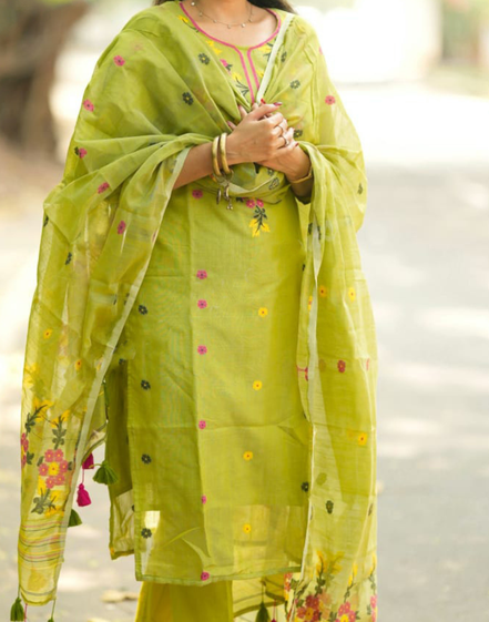 Woman wearing a green traditional outfit with floral patterns