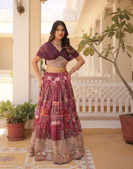 Woman in traditional outfit standing in a decorated indoor setting with plants.